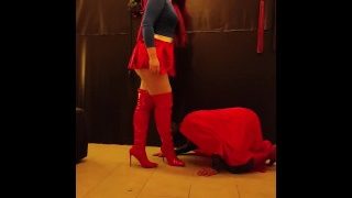 スーパーマンがスーパーガールのレザーブーツにキス