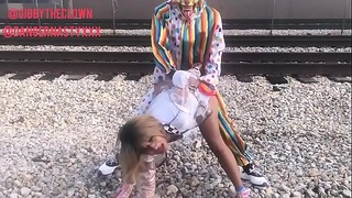 Клоун чука момиче на влакови релси