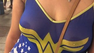Frau im durchsichtigen Wonder Women-Shirt mit gepiercten Brustwarzen in der Öffentlichkeit