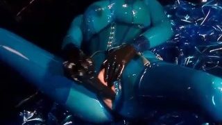 透明な青いラテックスキャットスーツとマスクを着た巨乳の重ゴム女神がオナニー – パート 4