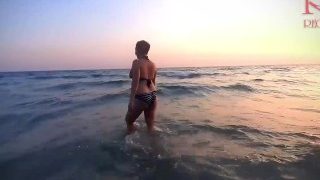 孤独的裸体主义者海滩上最性感的女士。黑色泳衣。黑色比基尼。